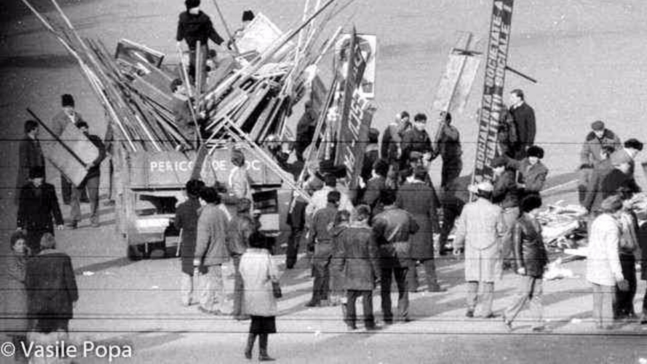 21 decembrie 1989. Gunoierii strang pancartele aruncate dupa mitingul lui Ceausescu. Foto: Vasile Popa